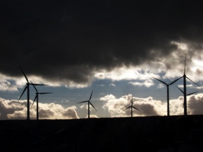 Wind turbines against dark clouds.