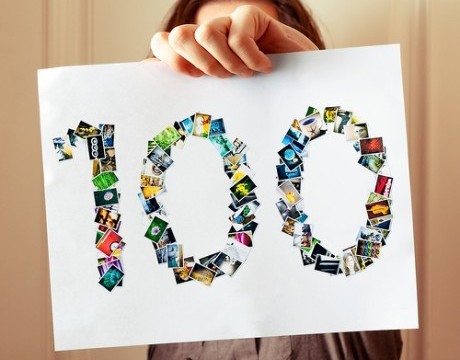hand holding "100" sign