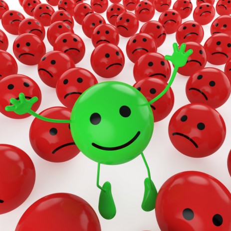 green smiley face amidst red frowny faces