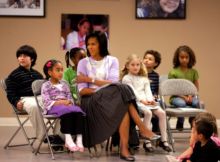 First Lady Michelle Obama sits with students during a visit to the LAMB bilingual school.