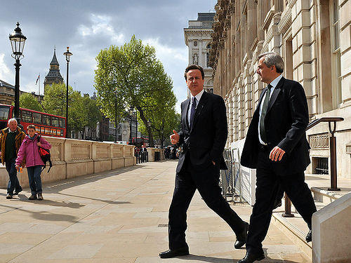 Prime Minister David Cameron and Energy and Climate Change Secretary Chris Huhne heading out to announce that the government will cut its greenhouse-gas emissions by 10 percent over the next 12 months.