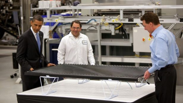 Obama examines a solar panel with Solyndra executives.