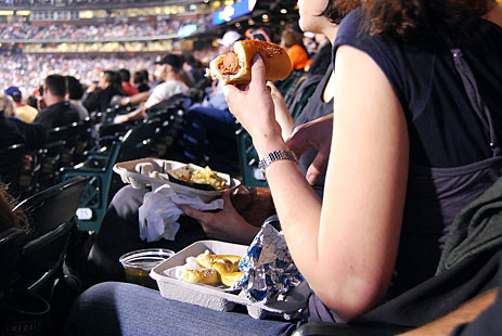 Woman eating hot dog at game