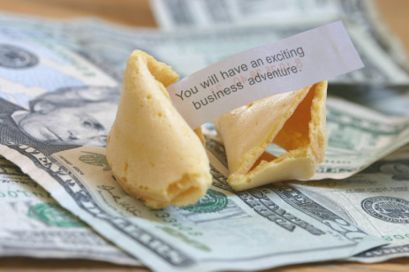 Fortune cookie on top of dollars.