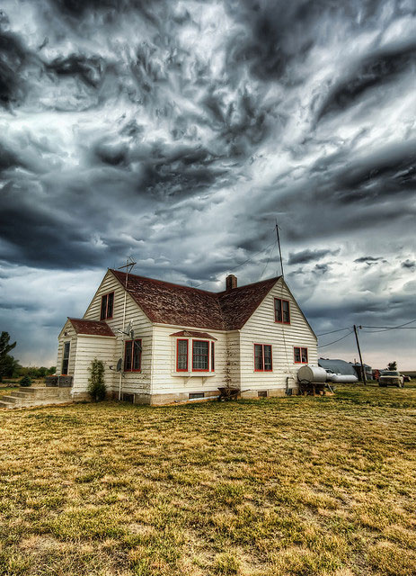 Tornado clouds over farmhouse