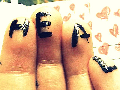 The word "heal" written on fingertips.