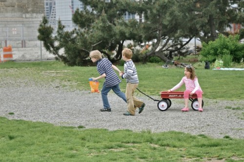 Kids with wagon in city park.