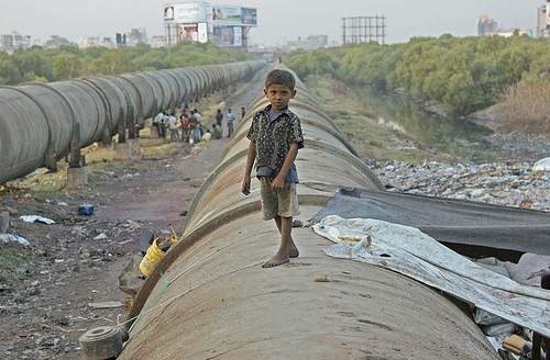 Little Indian boy on a pipe. 