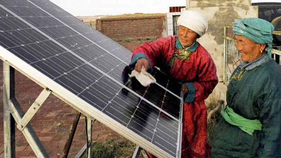 Women cleaning a solar panel.