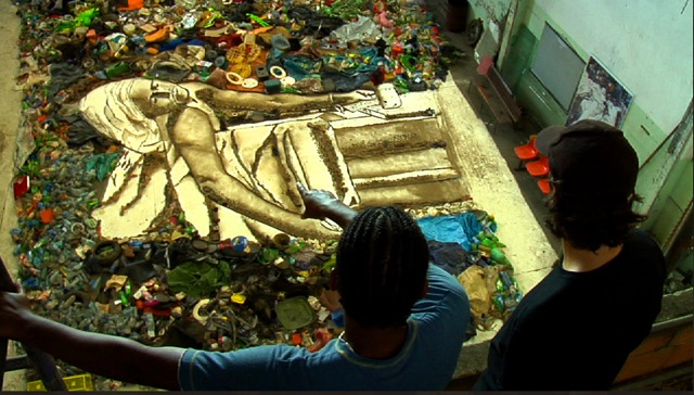 Artist looks at his work made of trash.