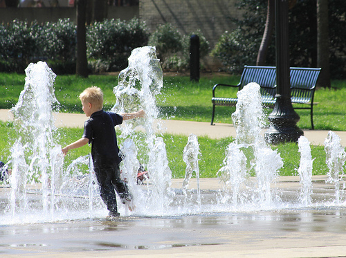 Kid playing in fountain.