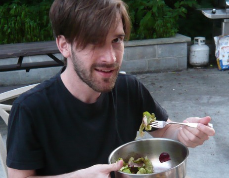 Man eating a salad, potentially a hegan.