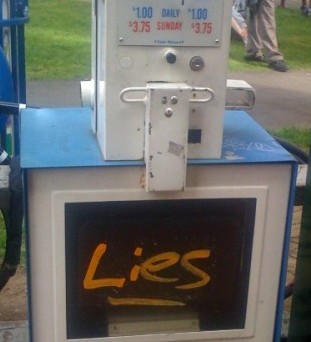 newspaper box with "lies" on it