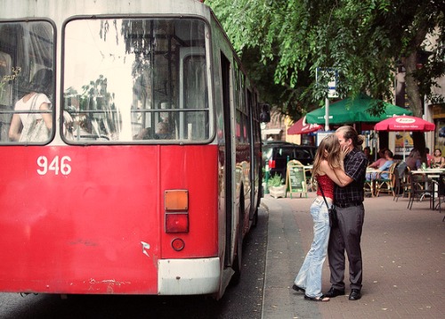 Couple kissing near a bus