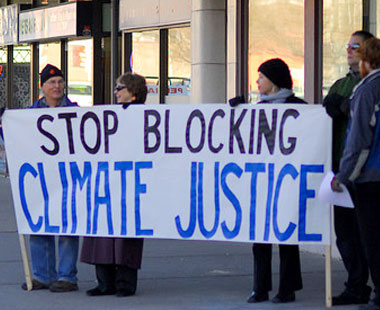 protestors with banner: "Stop blocking climate progress"
