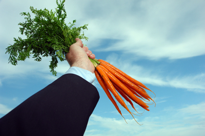 Business man holding carrots