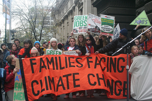 protest with big sign: "Families Facing Climate Change"