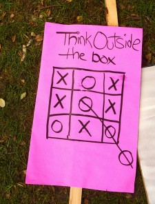 protest sign: "Think Outside the Box"