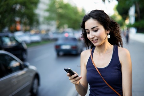 woman texting on sidewalk