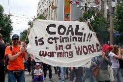 coal protest banner: "Coal is criminal in a warming world"