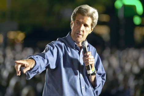 John Kerry points at a pile of stock