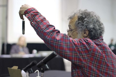 A man holds up a container of oil and sand as he testifies at last night's hearing