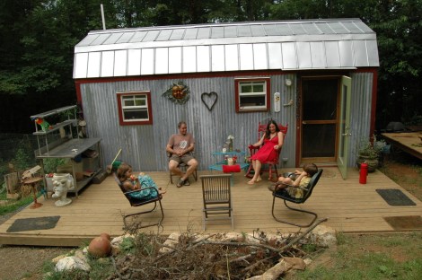The Berzins outside their 168-square-foot, mortgage-free home.