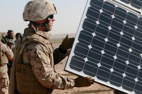 A United States Marine Corps engineer opens solar panels on a solar-powered water purification system in Afghanistan