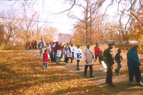Community members march in the park.