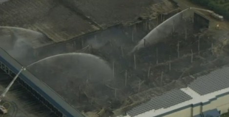 Firefighters spray what remains of the Dietz & Watson warehouse with water.