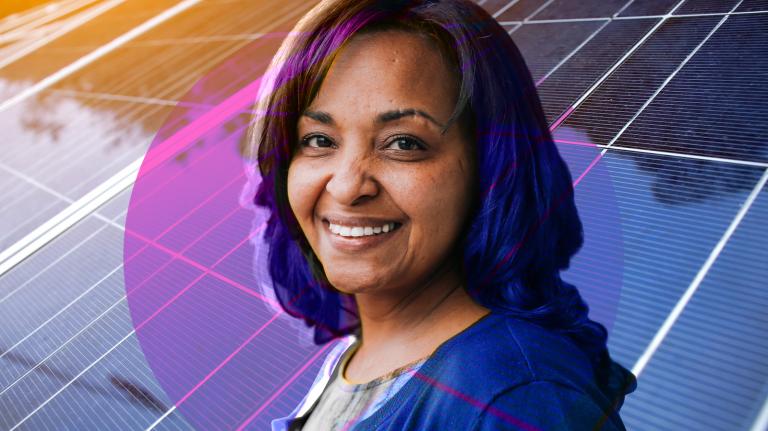 2017 Grist 50 Fixer Rahwa Ghirmatzion smiling with rows of solar panels in the background.