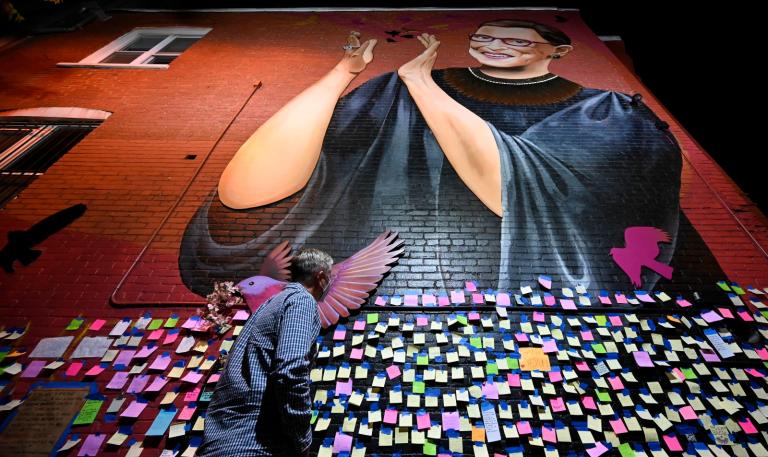 Man walks in front of a Ruth Bader Ginsburg memorial