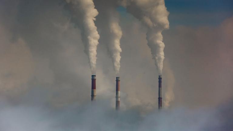 Three smokestacks emitting smoke