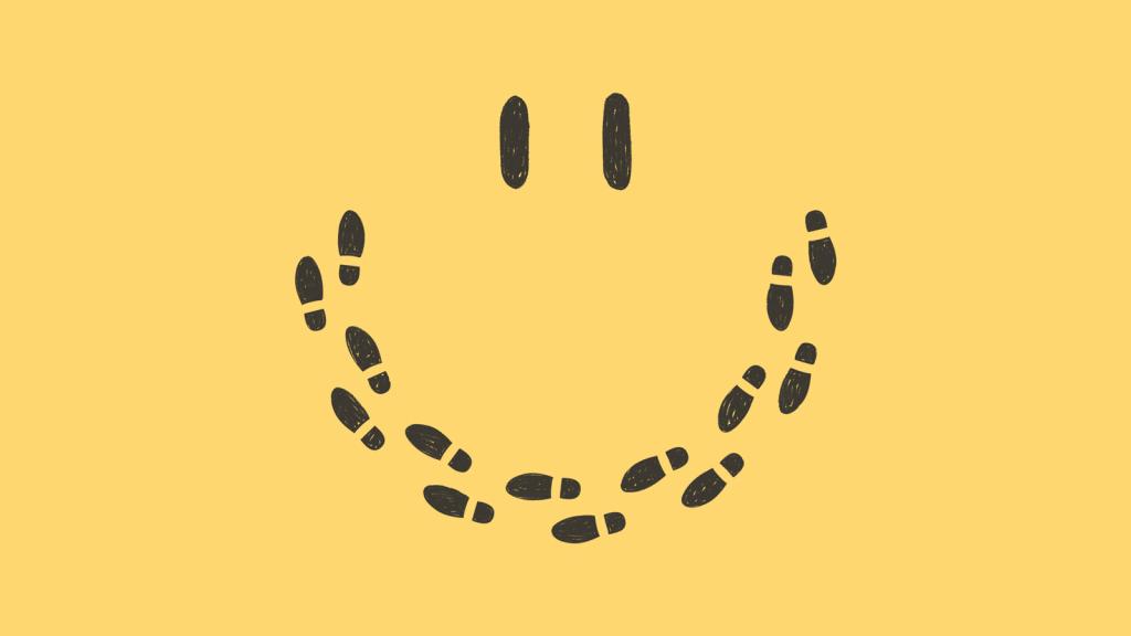 Conceptual illustration of smiley face made up of footprints on yellow background