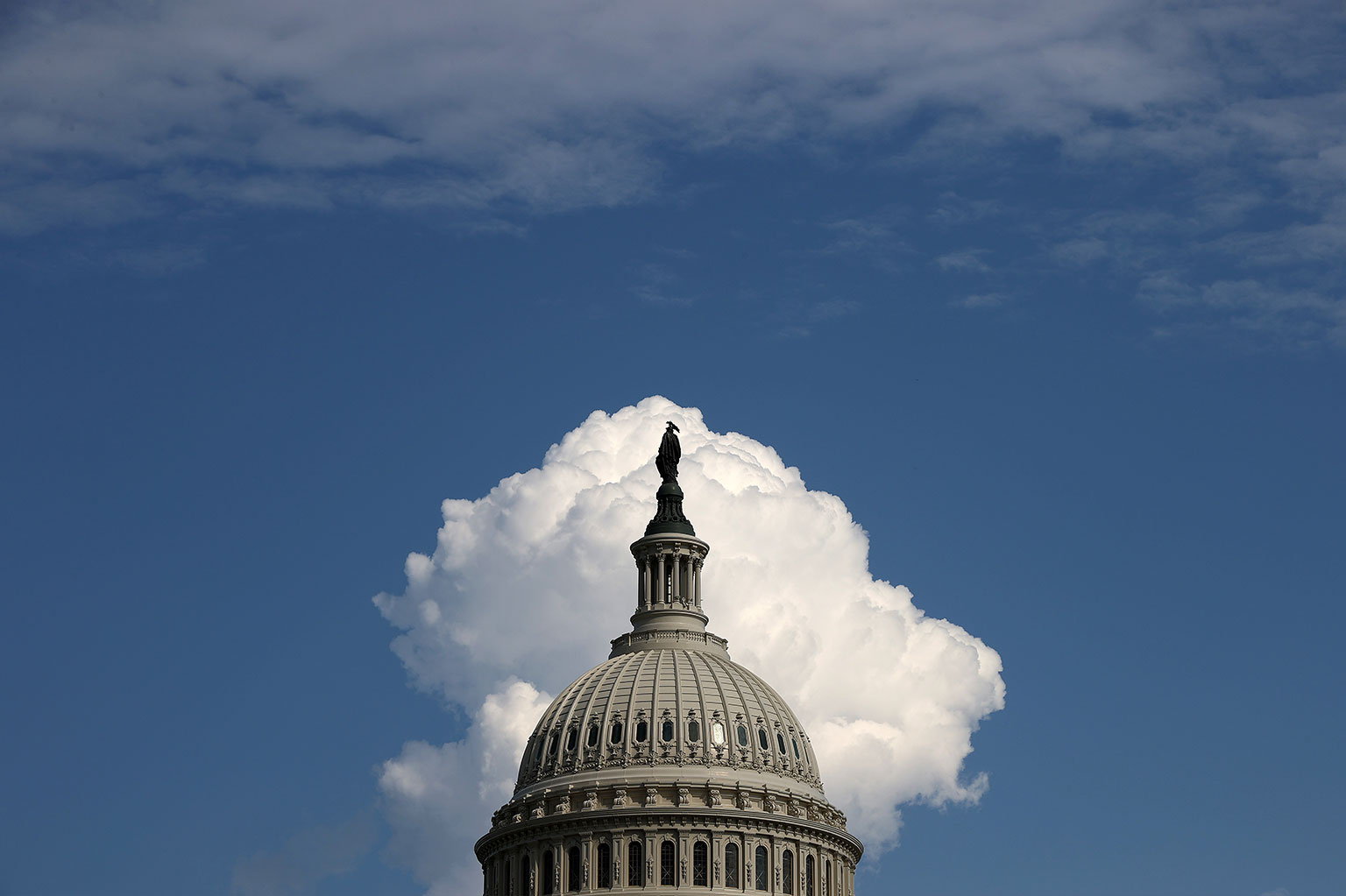 A cloud rises behind the U.S. Capitol dome