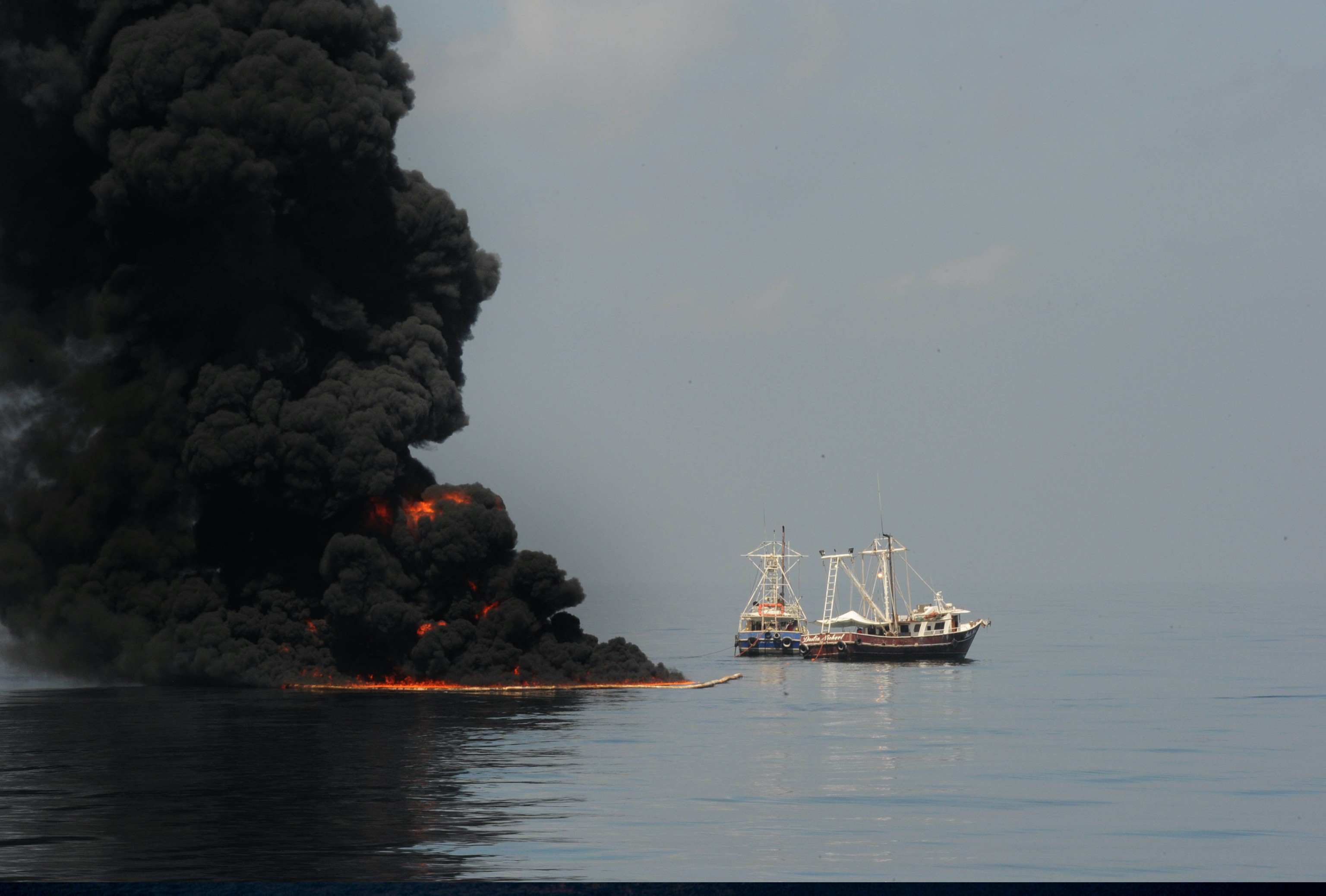 Two coast guard tugboats attempt to burn oil after the Deepwater Horizon oil spill
