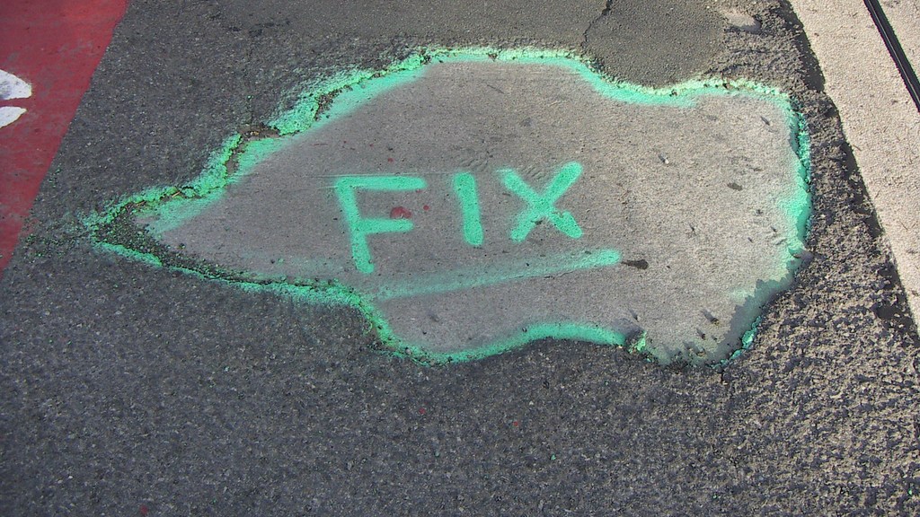 pothole with "fix" painted on it