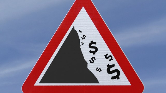 dollar signs falling down a cliff