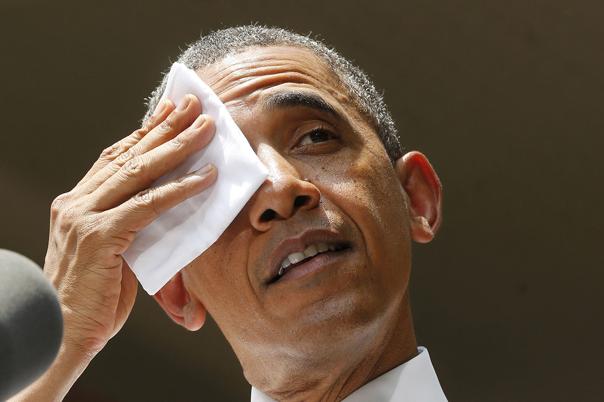 U.S. President Barack Obama wipes his forehead as he speaks about his vision to reduce carbon pollution while preparing the country for the impacts of climate change while at Georgetown University in Washington, June 25, 2013.