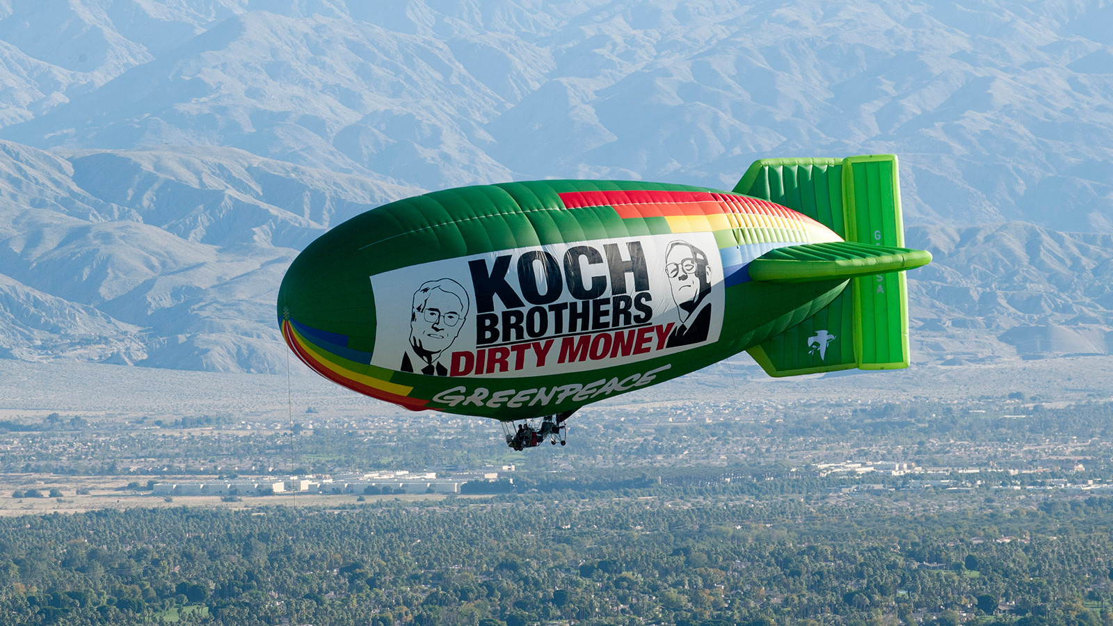 The Greenpeace Airship A.E. Bates flies over the location of oil billionaires David and Charles Koch's latest secret political strategy meeting, with a banner reading 