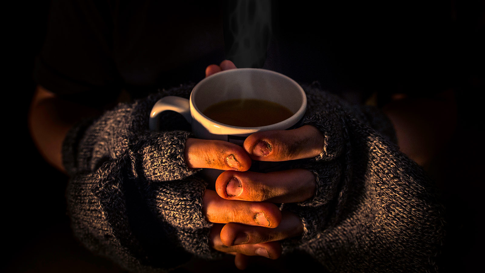 Homeless person holding a cup