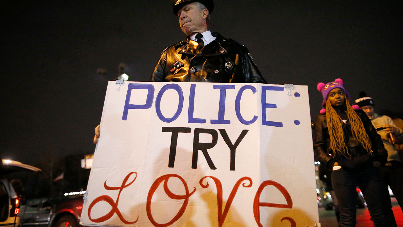 A man holds a sign outside the Ferguson Police Department in Ferguson, November 24, 2014.