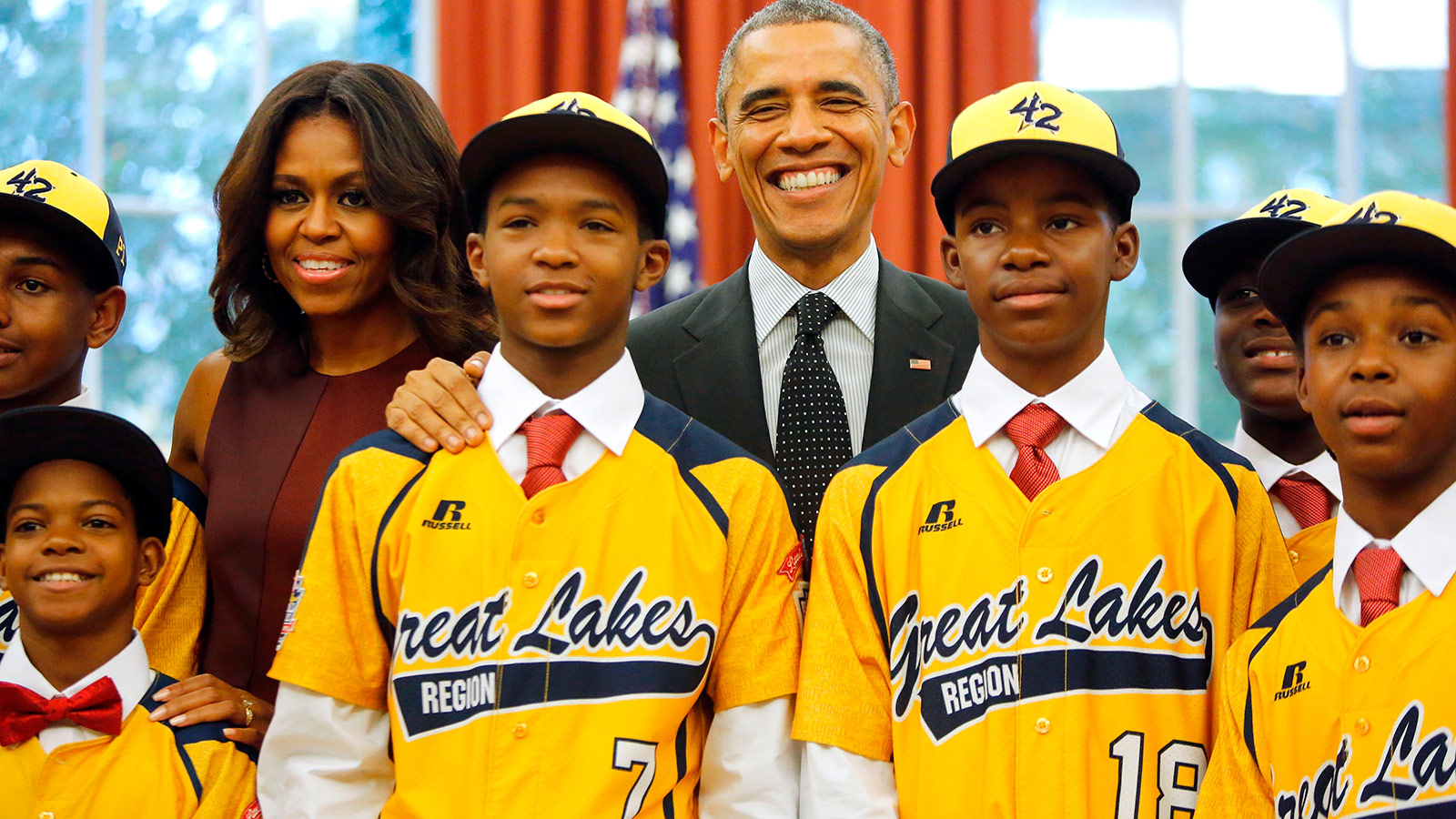 U.S. President Barack Obama and first lady Michelle Obama welcome members of the Jackie Robinson West All Stars Little League baseball team, including DJ Butler (bottom L), Lawrence Noble (#7), Eddie King (#18) and Jaheim Benton (far R), from Chicago in the Oval Office at the White House in Washington November 6, 2014. The team won the U.S. bracket of the Little League World Series this summer, before falling in the finals to the Seoul Little League of Seoul, South Korea.