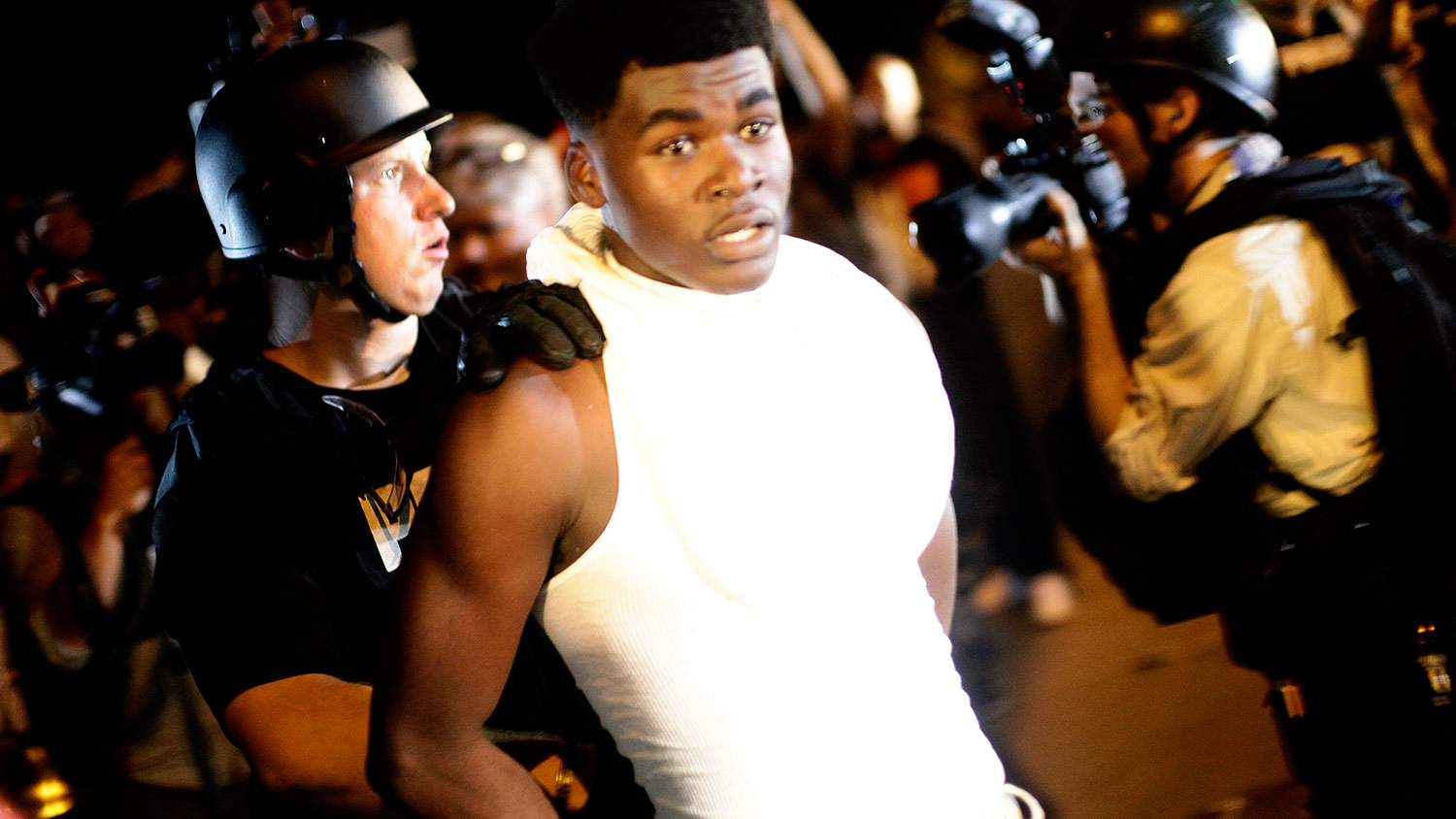 A police officer in riot gear detains a demonstrator protesting against the shooting of Michael Brown, in Ferguson, Missouri August 19, 2014.