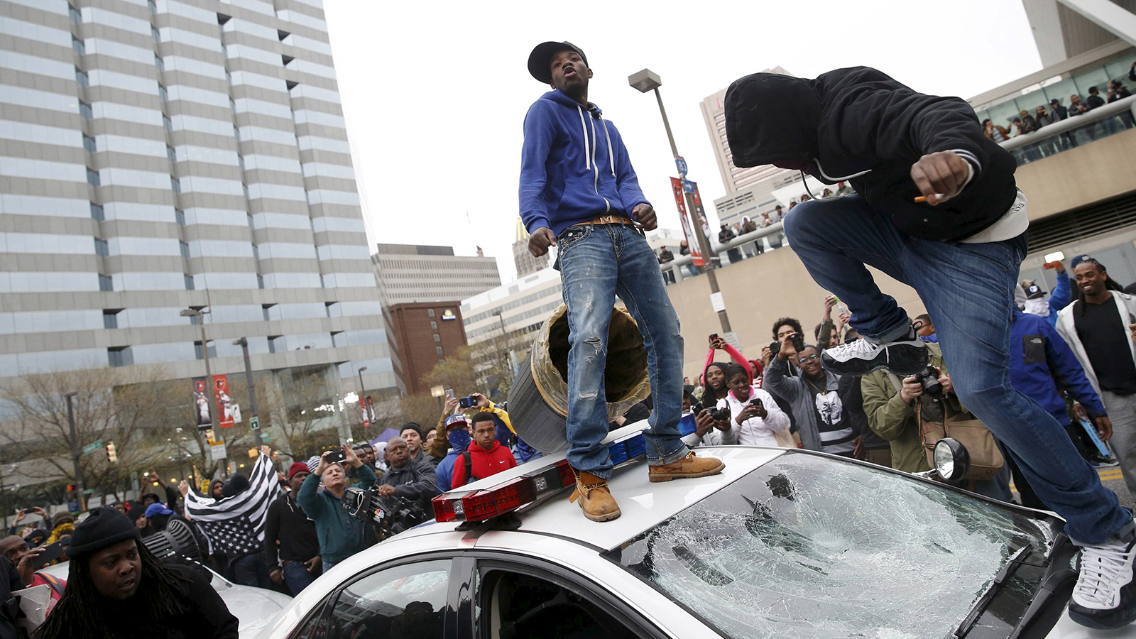 Protesters jump on a police car at a rally to protest the death of Freddie Gray who died following an arrest in Baltimore, Maryland April 25, 2015.