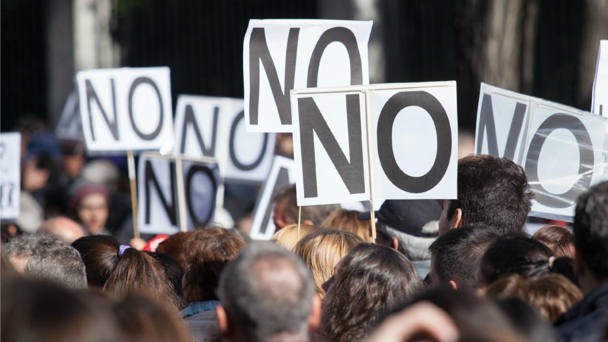 protesters holding "no" signs