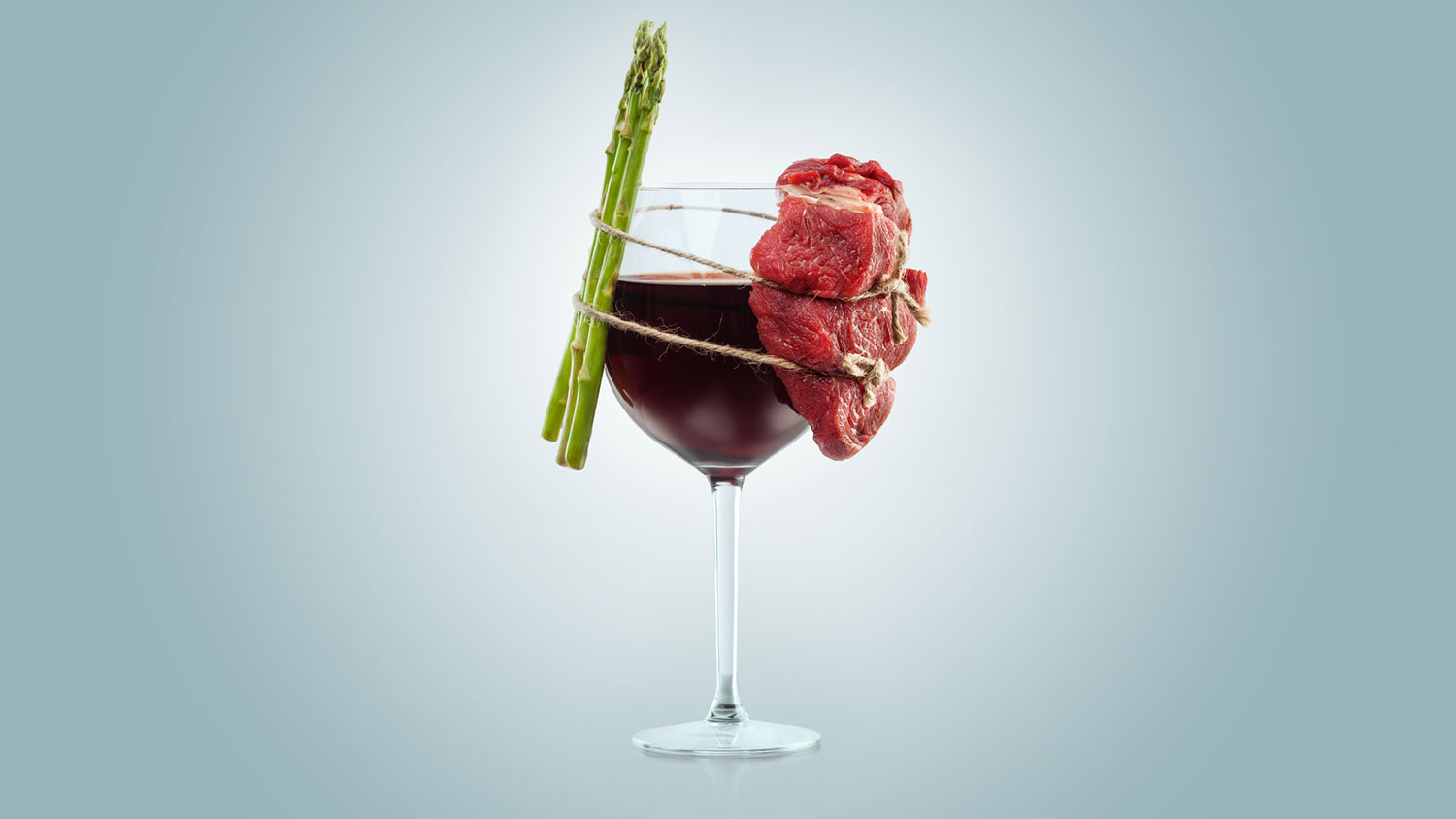 wine glass with asparagus and red meat