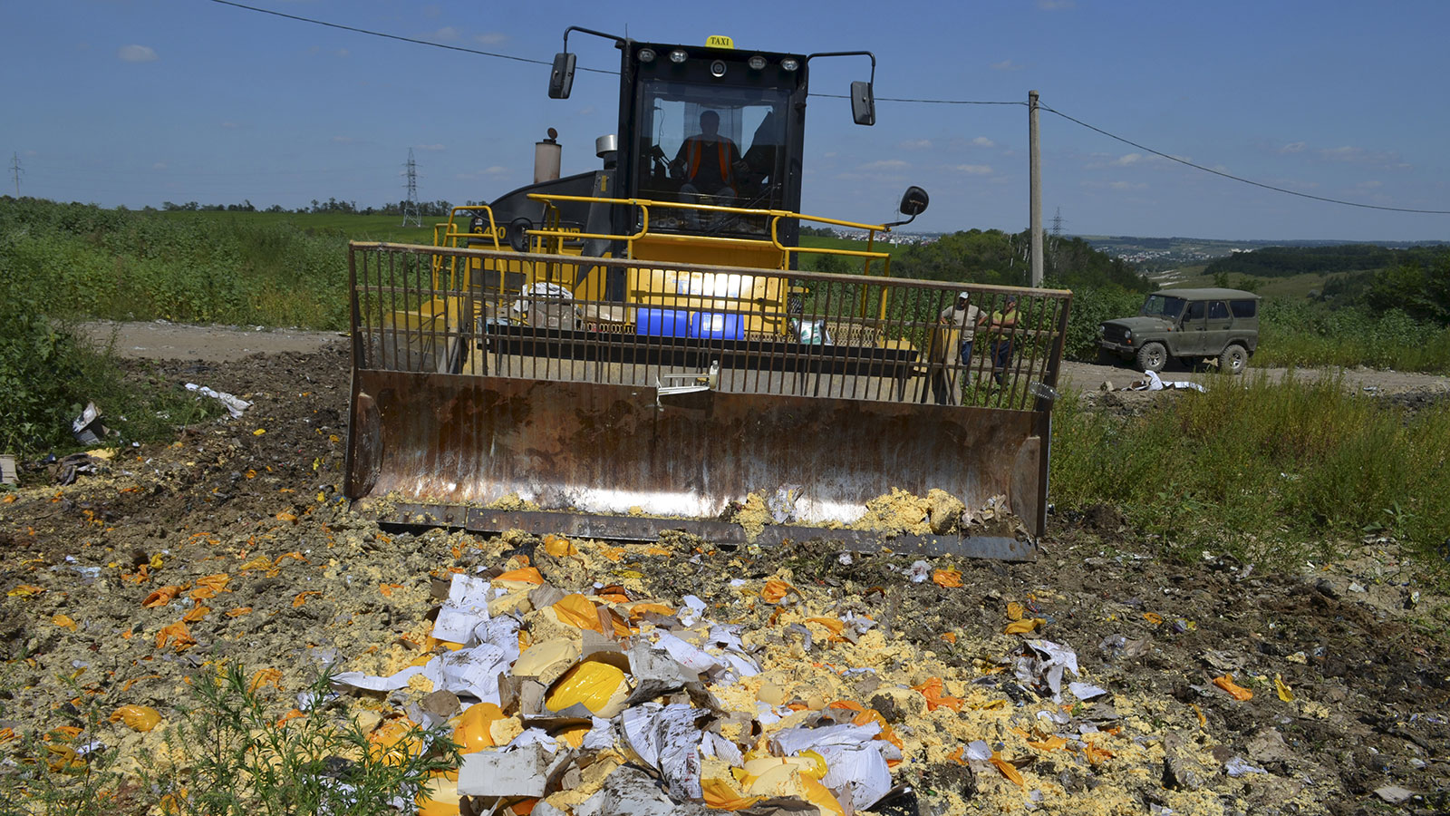 An employee operates a bulldozer while destroying illegally imported food falling under restrictions in Belgorod region, Russia, August 6, 2015