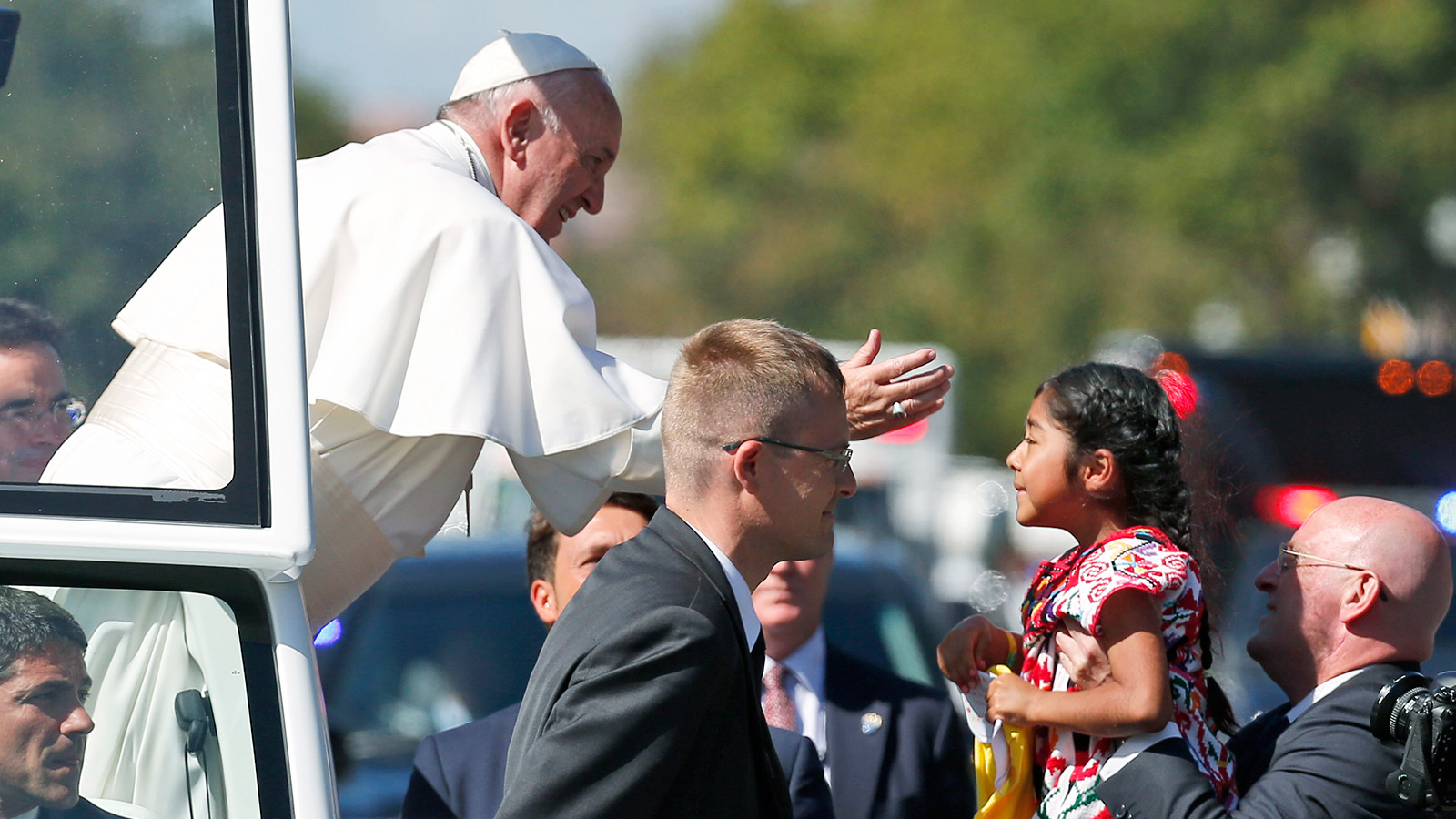 Pope Francis reaches for Sophia Cruz during a papal parade in Washington.