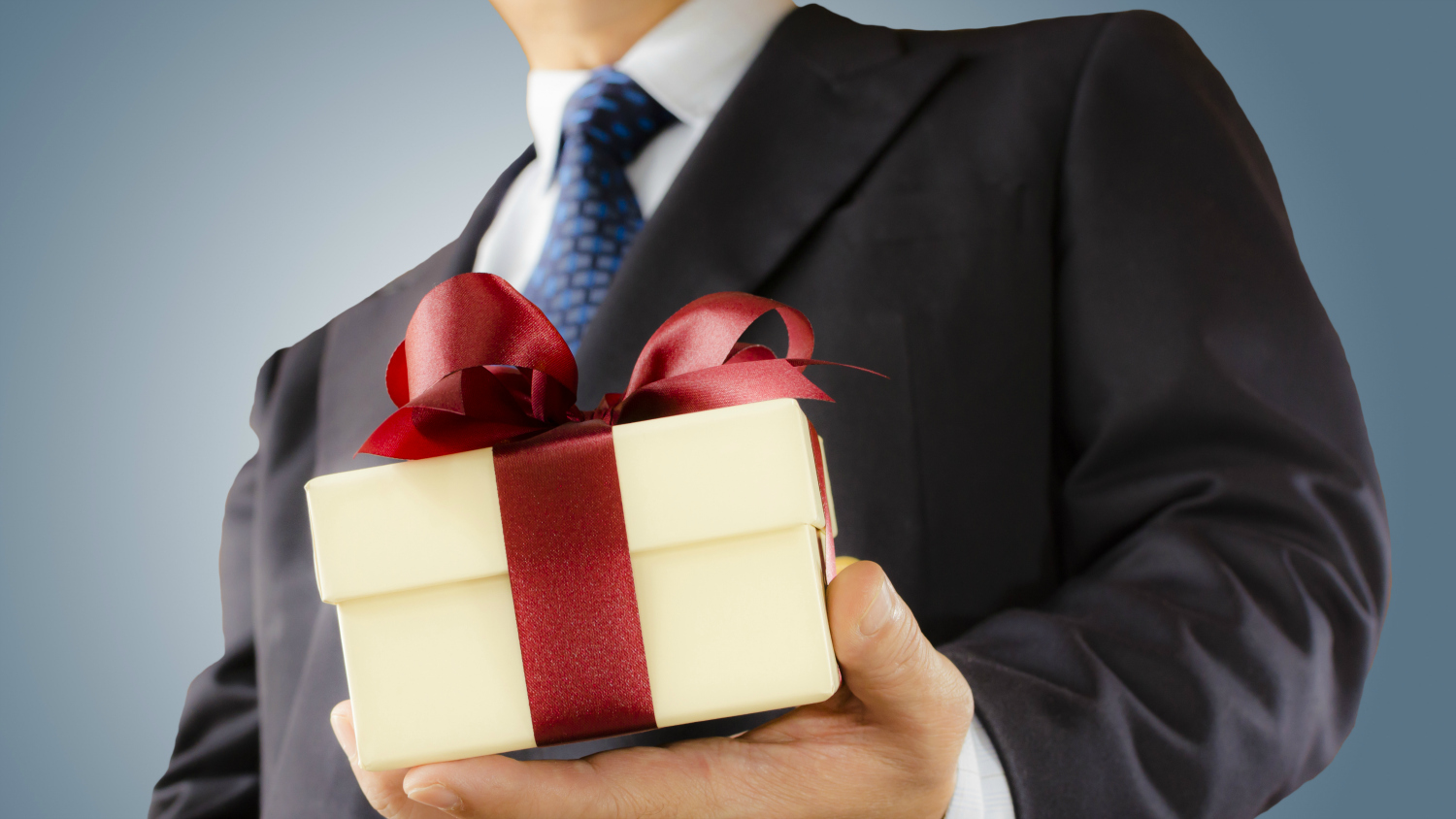 suited man offering gift